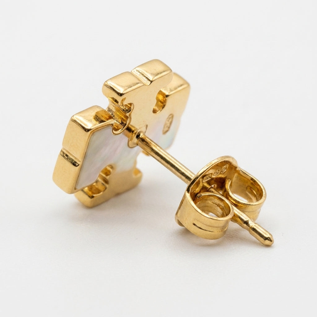 Macro shot of the vibrant enamel color and the polished gold Double T logo on small stud earrings