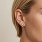 Model wearing Tory Burch Small Icon Enamel Earrings, showcasing a delicate and modern jewelry look