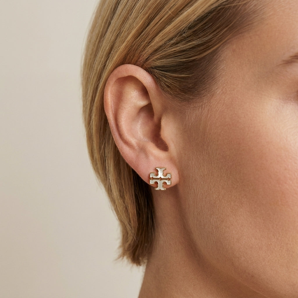 Model wearing Tory Burch Small Icon Enamel Earrings, showcasing a delicate and modern jewelry look