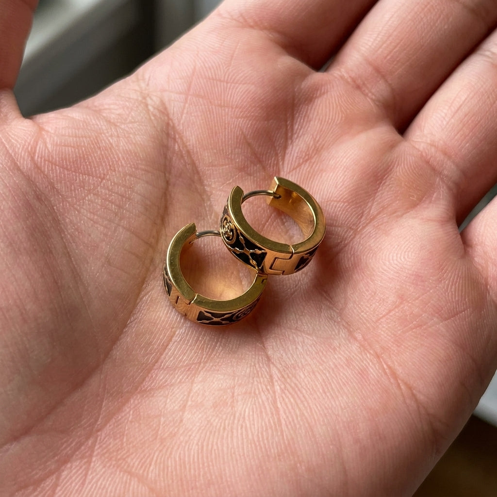 Hand-held size comparison of Tory Burch Small T Monogram Hoops to show the petite 15mm diameter