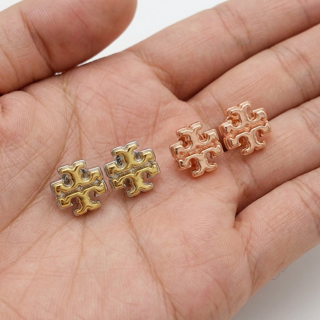 Hand-held size reference of Tory Burch logo studs for accurate scale and fit visualization