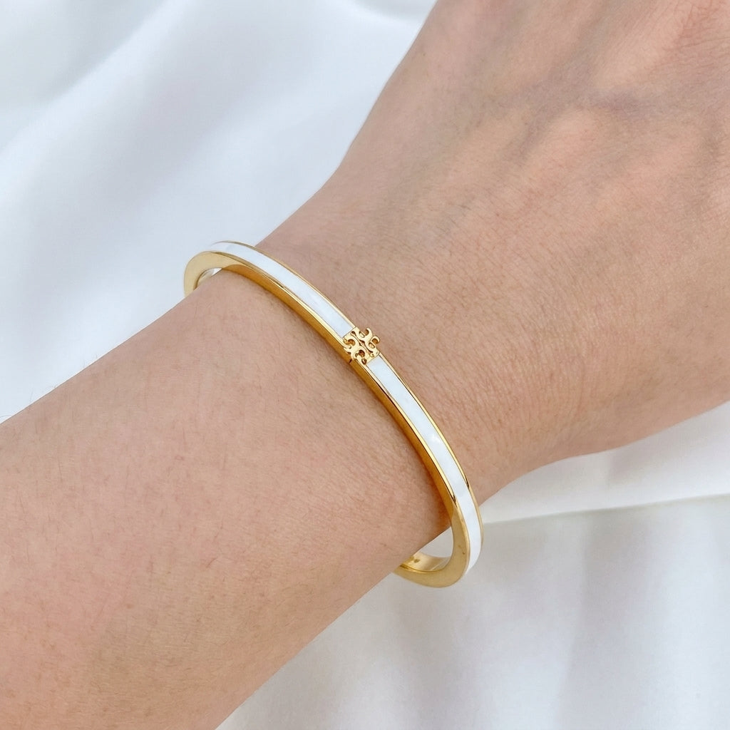 Model wearing the Tory Burch Thin Enamel Bracelet, ideal for a chic and minimal jewelry stack