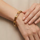 Model wearing Tory Burch White and Gold Bangle, showcasing a chic and effortless luxury style