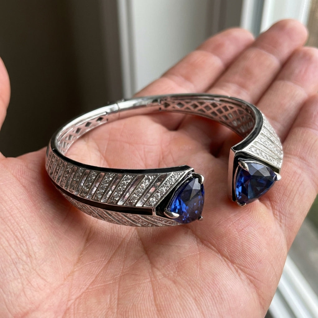 Silver bracelet with blue gemstones held in a hand