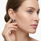 Model wearing vibrant turquoise enamel gold open hoop moissanite earrings in a lifestyle portrait.
