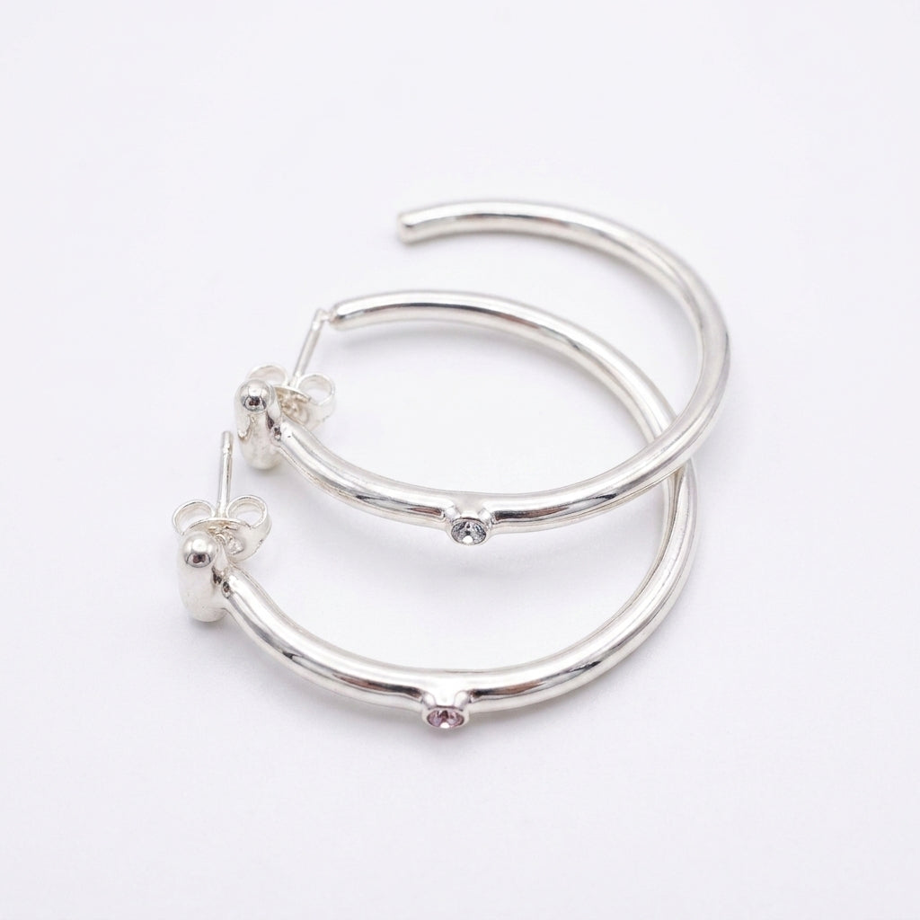 UNOde50 Ser Indomable Hoop Earrings featuring sterling silver plating and sparkling white topaz