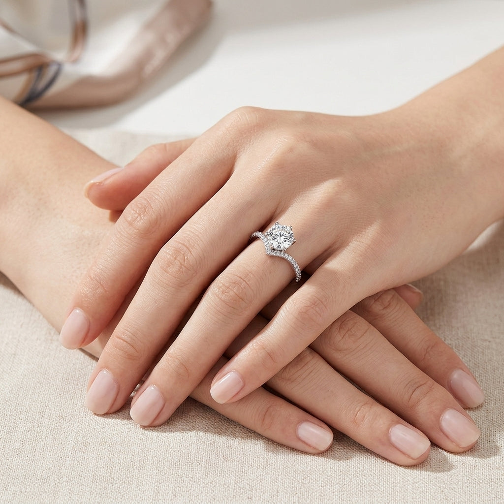 Close-up view of woman's hands wearing round cut diamond v-shape chevron ring.