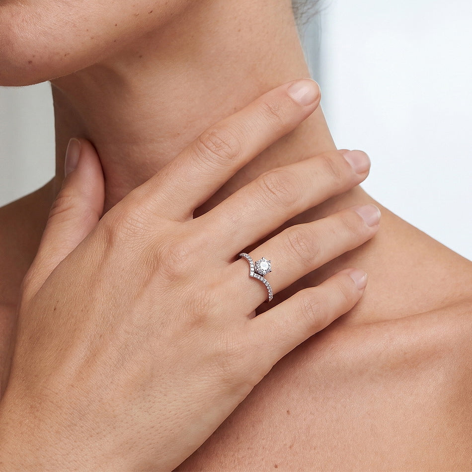 Model wearing round diamond six-prong v-shape chevron engagement ring.