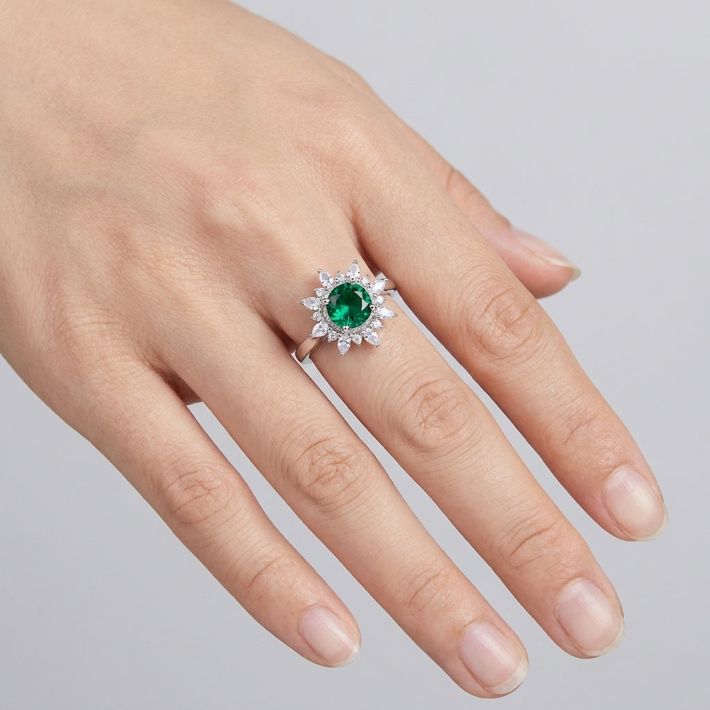 Ring with a green gemstone on a finger against a gray background