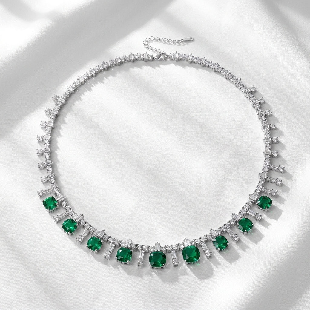 Flatlay view of a vintage cushion-cut emerald fringe statement necklace under soft shadows.