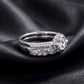 Vintage milgrain halo lab grown diamond engagement ring stacked with matching wedding band on dark black silk