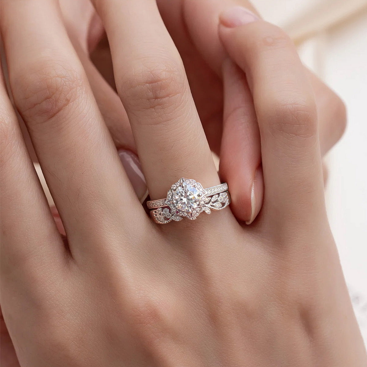Woman wearing vintage milgrain halo lab grown diamond bridal ring set stacked on finger