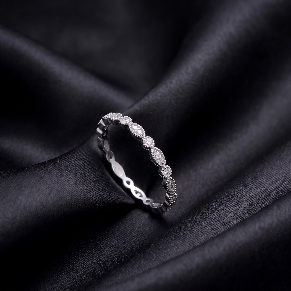 Side profile view of vintage milgrain marquise and round lab grown diamond band standing on black silk