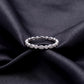 Vintage milgrain marquise and round lab grown diamond wedding band resting flat on dark black silk