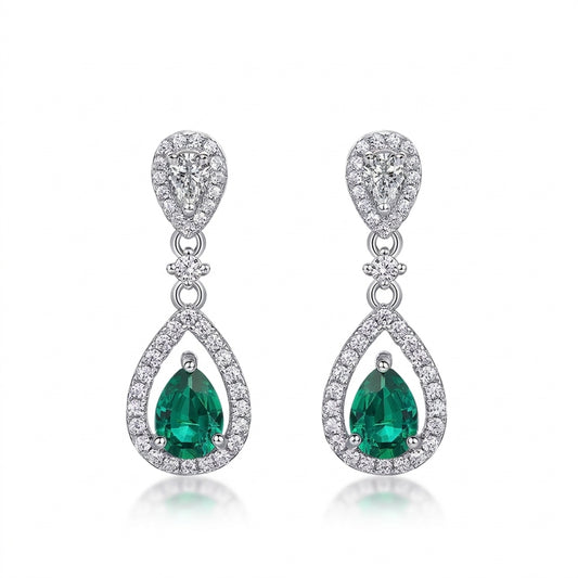 White background front view of a pair of vintage pear-cut emerald hollow halo drop earrings.