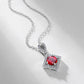 Side angle studio view of a vintage round-cut ruby rhombus pendant necklace casting a soft shadow on a white surface.
