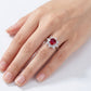 Hand wearing a ring with a red gemstone on a white background
