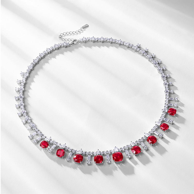 Flatlay view of a vintage cushion-cut ruby fringe statement necklace with soft shadows.