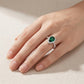 Real-life lifestyle hand view of a model wearing a vintage teardrop emerald halo statement ring with a pave shank.