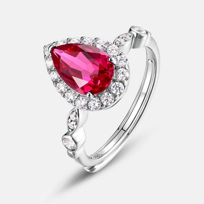 Three-quarter studio product view of a vintage teardrop lab ruby halo ring with an Art Deco marquise-shaped pave shank.