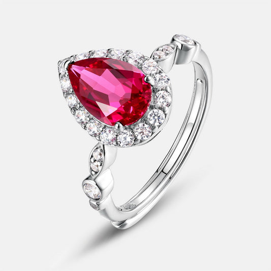 Three-quarter studio product view of a vintage teardrop lab ruby halo ring with an Art Deco marquise-shaped pave shank.