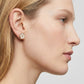 A model wearing the Tory Burch Forget Me Not Earrings to demonstrate the size and elegant look for daily wear.