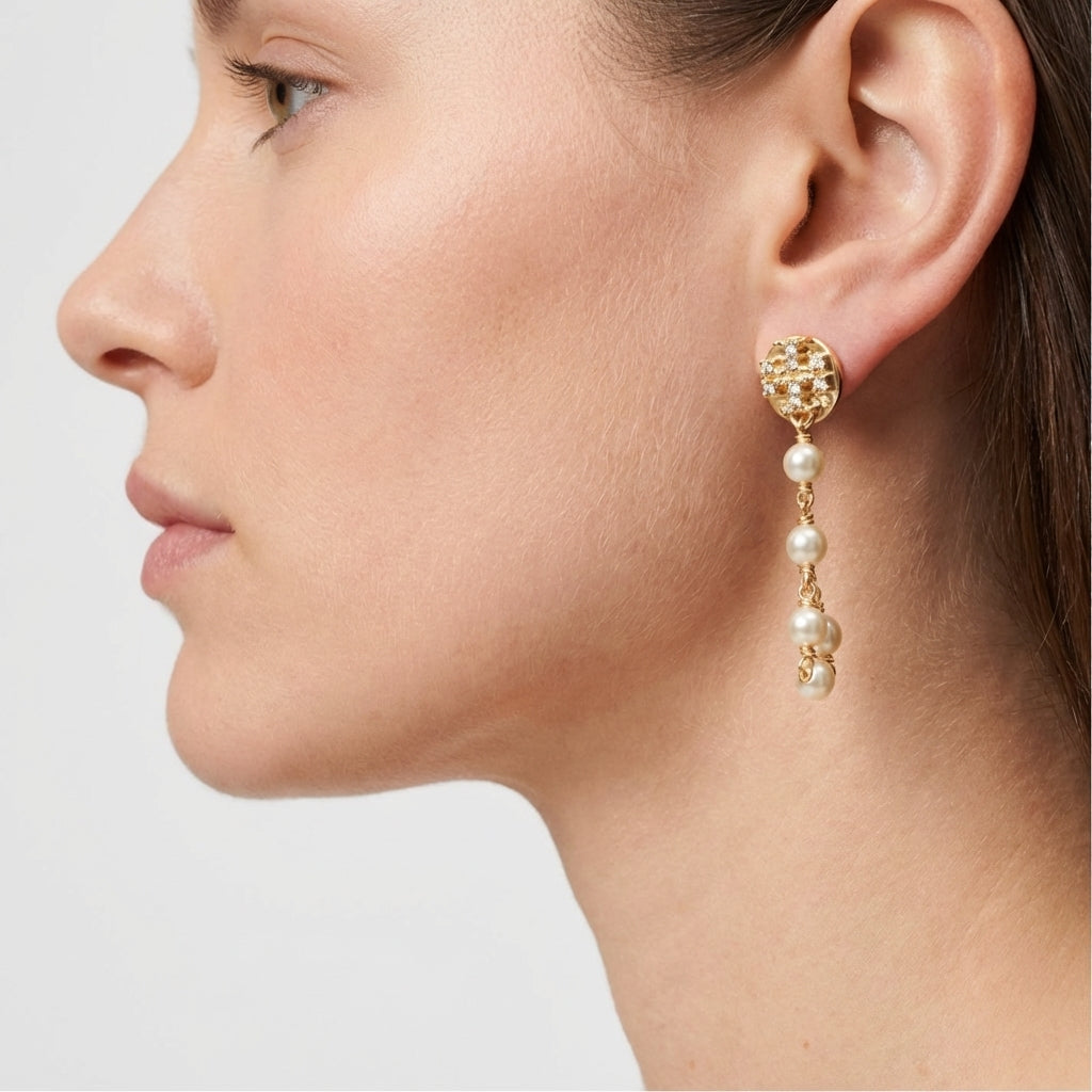 Model wearing the gold Tory Burch Moondance Pearl and Chain Earrings to show the long drop length and styling.