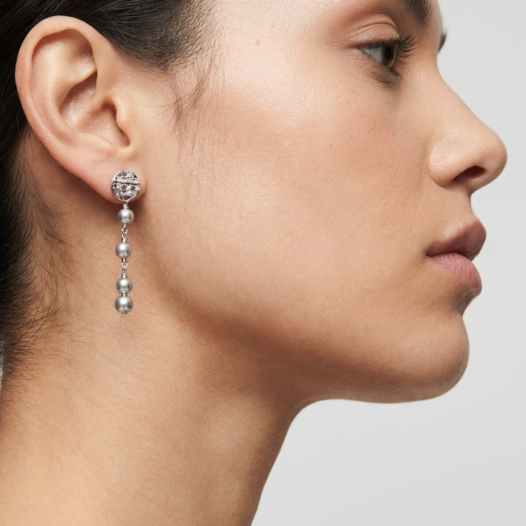 Model wearing the silver Tory Burch Moondance Pearl and Chain Earrings highlighting the dangling pearl aesthetic.