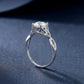 Angled shot of round brilliant woven infinity solitaire ring on blue surface.