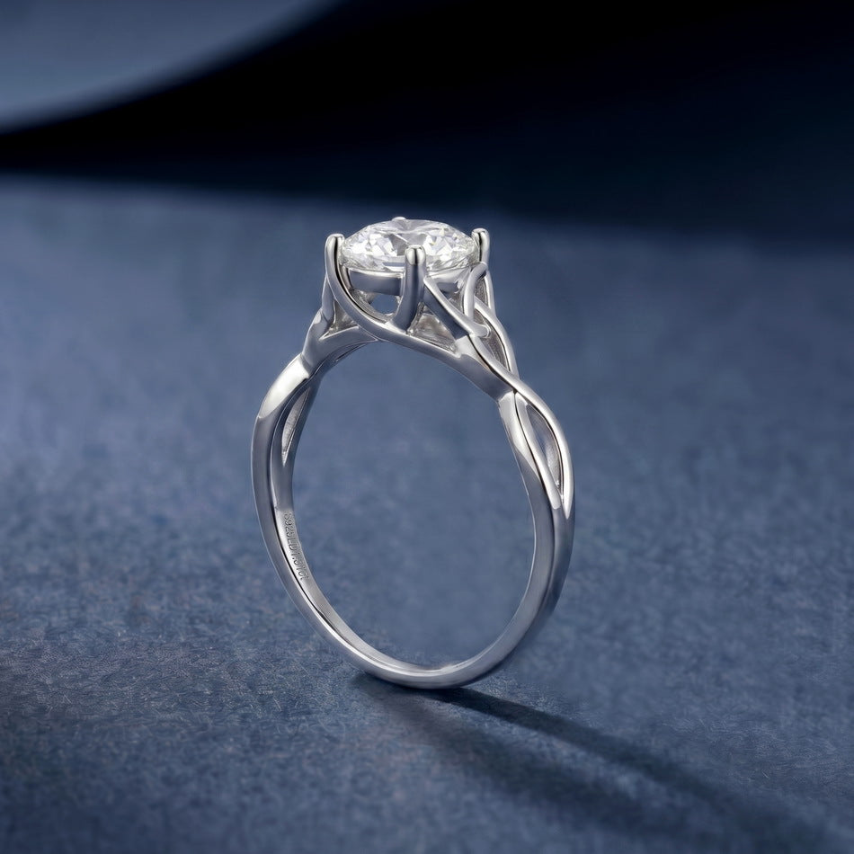 Angled shot of round brilliant woven infinity solitaire ring on blue surface.