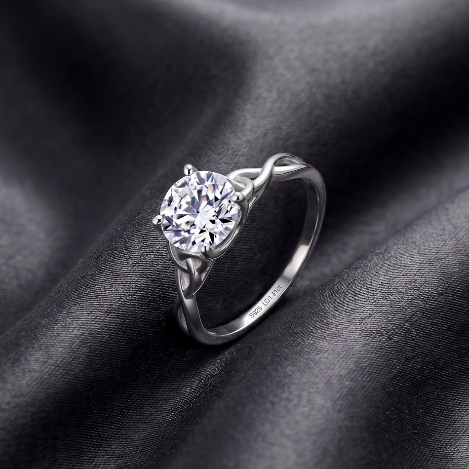 Perspective shot of round brilliant woven infinity solitaire ring on dark silk.